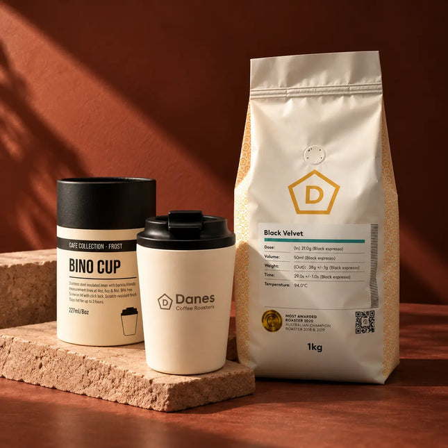 Danes Black Velvet coffee and branded Fressko reusable cup displayed against a warm terracotta background.